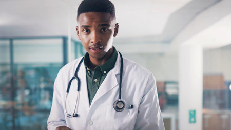 Portrait, doctor and black man in hospital for cardiology, healthcare or wellness. African person, medical professional and support in clinic lobby for specialist, about us and service in Kenyaの写真素材