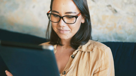 Creative, online and woman with tablet, lounge and happy with article draft, freelancer and reporter. Reading, story and person with tech for project, journalism and remote work for news in homeの写真素材