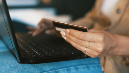 Credit card, hands and woman with laptop for online shopping, internet banking and website deal. Home, apartment and person with debit info on computer for digital purchase, payment and ecommerceの写真素材