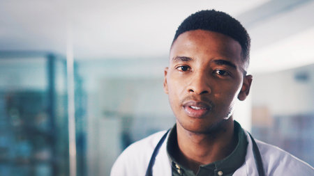 Portrait, doctor and black man in hospital for serious, healthcare and wellness. African person, medical professional and support in health clinic lobby for confidence, about us and space in Kenyaの写真素材