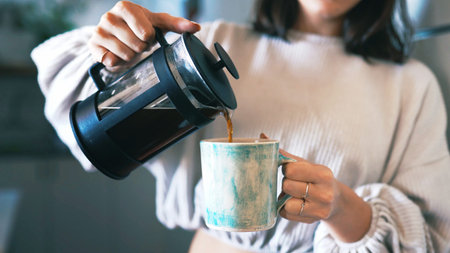Hands, coffee press and mug in home, kitchen and pour with warm beverage, espresso and liquid....