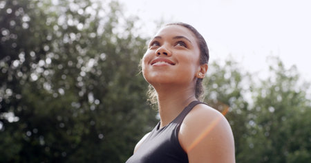 Thinking, woman or smile in nature for fitness mindset, healthy body goals or exercise idea. Reflection, female person outdoor or getting ready for cardio workout, wellness or contemplating training.の写真素材