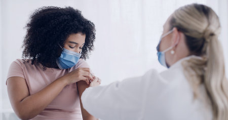 Healthcare mask, doctor or woman with injection in clinic for flu vaccine, medicine or immune booster. Immunization, expert and patient in hospital for influenza shot, medical service and treatmentの写真素材