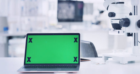 Laptop, green screen and microscope in laboratory for research, medical study and testing sample....