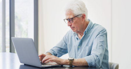 Old man, laptop or research in home for retirement planning, pension policy or finance management. Elderly person, typing or computer with inheritance info, estate preparation and trust fund website.の写真素材