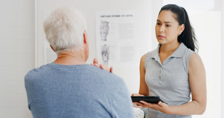 Woman, physiotherapy and senior man with tablet for wellness, rehabilitation and physical therapy. Healthcare, consulting and person on digital tech with patient for medical service, help or recoveryの写真素材