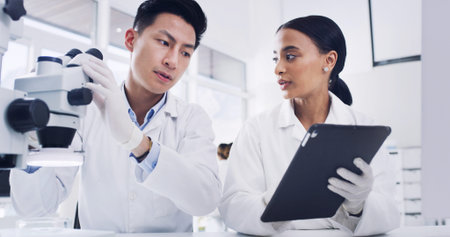Science, microscope and team with tablet in laboratory for microbiology, innovation or planning....