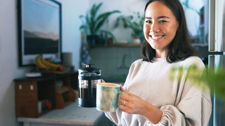 Woman, coffee press and portrait in kitchen, home and pride with warm beverage, mug and smile. Person, cup and kettle with morning routine, confident or happy for caffeine drink at house in Cambodiaの写真素材