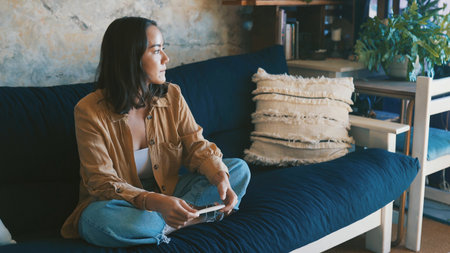 Pregnancy test, result and woman on couch with anxiety, maternity or wait in fertility outcome. Health, worry and female person in living room with medical stick, IVF and news in infertility risk.の写真素材