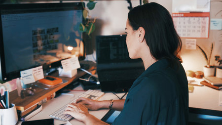 Remote work, editing and woman in home office with monitor, online research and review. Creative, WFH and graphic designer at desk with tech, digital and logo art analysis for projectの写真素材