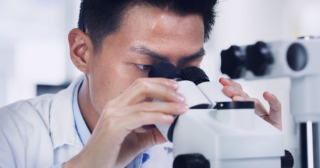 Man, scientist and forensic research with microscope for medical or discovery in laboratory. Male person, scientific or study with biotechnology or results for science investigation, exam or testの写真素材