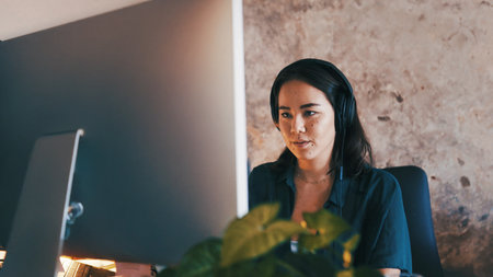 Remote work, headphones and woman on computer in home for copywriting, article review and editing. Creative, freelancer and person with music, audio and sound for research, website content or reportの写真素材