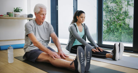 Fitness, healthcare or stretching with old man and physiotherapist in studio for rehabilitation routine. Consulting, exercise or recovery with practitioner and senior patient in session for therapyの写真素材