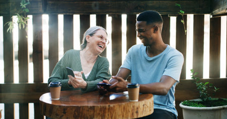 Cafe, entrepreneur or employee laughing with phone, funny review or online comment for restaurant. Flare, positive feedback or happy people with mobile in coffee shop, reading website or social mediaの写真素材