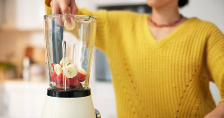 Kitchen, hands and woman with blender for smoothie in morning for healthy drink, diet and detox. Home, protein shake and person with ingredients, fruit and food for nutrition, wellness and vitaminsの写真素材