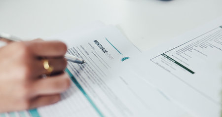 Pen, contract and hands of person with signature in office for mortgage, legal documents or title deed. Paperwork, agreement and woman with registration, sign up or application for insurance loanの写真素材