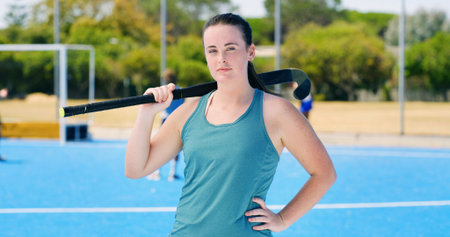 Portrait, hockey stick and woman with training, outdoor and fitness with competition. Person, player and healthy athlete with exercise, practice and confidence with equipment, workout and balanceの写真素材