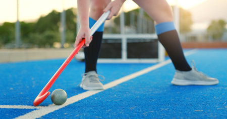 Hockey stick, ball and legs on turf for training practice, physical activity or outdoor sports game. Fitness, coordination or person with control on field for passing, match preparation or equipmentの写真素材