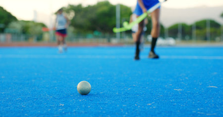 Hockey stick, ball and legs on field for training practice, physical activity and sports game outdoor. Fitness, coordination and people running on astro turf to pass, players and match preparation.の写真素材
