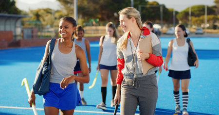 Walking, hockey and women outdoor with coach talking after training, practice and exercise. Team,...