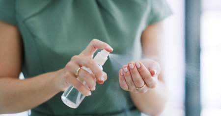 Hands, person and spray sanitizer in office for hygiene, disinfection and germ protection. Closeup, woman and bottle and antibacterial liquid for health safety, virus prevention and infection controlの写真素材