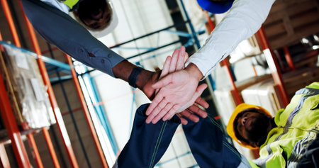 Hands together, team and low angle at warehouse for logistics, motivation or connection for career at plant. People, group and stack for supply chain, celebration or inventory management for shippingの写真素材
