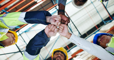 Hands, fist bump and team with low angle at warehouse for logistics, motivation or connection at plant. People, group and synergy for supply chain, celebration and inventory management for shippingの写真素材