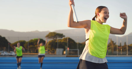 Happy, athlete and woman cheering for hockey success, fitness achievement and sports champion. Excited, female person and celebration for competition victory, score goal and tournament accomplishmentの写真素材
