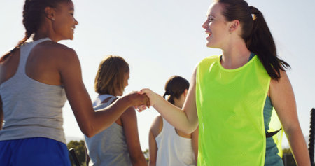 Sport, team and women with handshake outdoor for hockey tournament, game start and greeting. Fitness, happy and players shaking hands at competition for sportsmanship, friendly match or introductionの写真素材