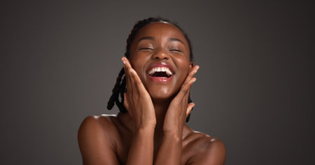 Beauty, skincare and girl with laughing in studio for natural glow, radiance and healthy skin. Mockup space, black woman and happy on gray background for hydration treatment results and dermatologyの写真素材