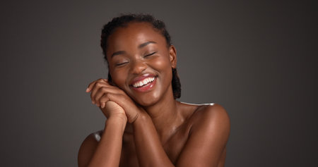 Woman, smile and skincare for glow, studio and natural cosmetics for healthy skin or gray background. Mockup space, black person and bodycare with dermatology, self care and happy for hydrationの写真素材