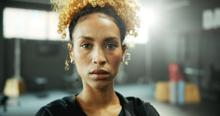 Portrait, serious and African woman at gym with fitness pride, ready for workout and exercise. Confident, female person and start of training, sports assistance and membership at wellness facilityの写真素材