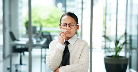 Business girl, portrait and kid thinking with decision for company play or junior internship. Idea, child or pretend intern with glasses or plan for choice, costume or problem solving in workplaceの写真素材