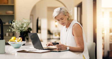 Mature woman, credit card and typing on laptop in home for online shopping or remote banking app....