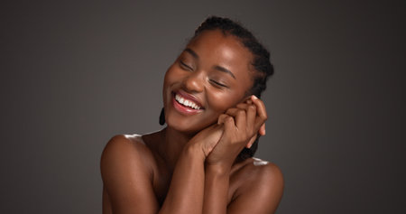 Happy, woman and skincare for glow, studio and natural cosmetics for healthy skin or gray background. Mockup space, black person and self care with dermatology, smile and confident for hydrationの写真素材