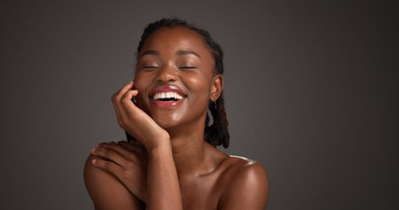 Beauty, happy and woman with skincare in studio for natural glow, hydration or healthy skin. Mockup space, black girl or smile on gray background for collagen treatment results and self care radianceの写真素材