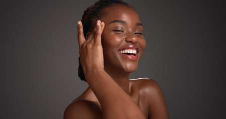 Portrait, woman and skincare for glow, beauty and natural cosmetics for healthy skin or mockup space. Gray background, black person and self care with dermatology, smile and confident for hydrationの写真素材