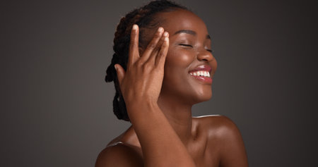 Confident, woman and skincare for glow, studio and natural cosmetics for healthy skin and self care. Mockup space, black person and bodycare with dermatology, gray background and happy for hydrationの写真素材