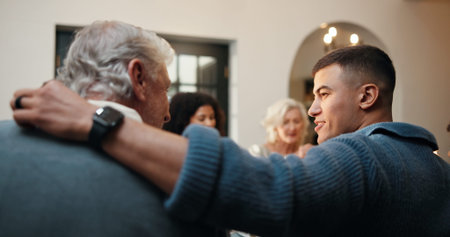 Conversation, hug and man with father in dining room of home for Christmas celebration together....