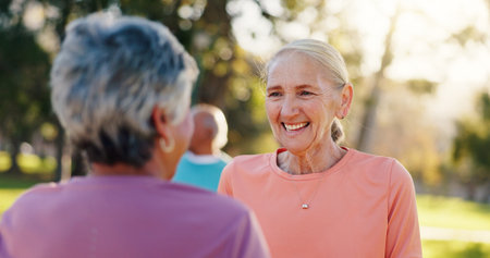 Smile, senior woman and friends for fitness outdoor with discussion, exercise and bonding together. Happy, elderly people and talking for pilates session, training break and chat for wellness at parkの写真素材
