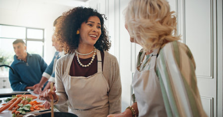 Cooking, help and family in kitchen for lunch, supper and prepare food for bonding in home. Culinary skills, social gathering and people for meal prep, cutting vegetables and thanksgiving dinnerの写真素材