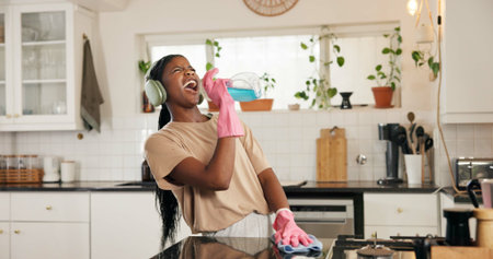 Cleaning, singing and black woman in kitchen with spray bottle for hygiene, disinfection and...