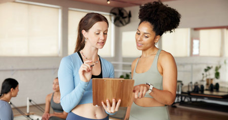 Fitness, clipboard and women in studio, talking and support with pilates schedule. People, gym owner...