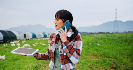 Agriculture, phone call and tablet with woman on chicken farm for planning, strategy or sustainability. Communication, poultry and thinking with farmer outdoor on grass field for livestock managementの写真素材