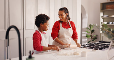 Christmas, mother and child with baking in kitchen for festive cookies, teaching recipe and help. African family, people or rolling pin in home for dough preparation, xmas snacks or holiday traditionの写真素材