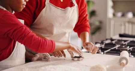 Hands, parent and child with baking in kitchen for biscuit recipe, culinary skills and help. Family, people and cookie cutter with learning in home for dough preparation, weekend snack or developmentの写真素材