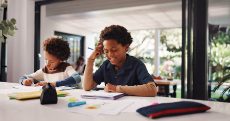 Thinking, homework and children in house with education, learning or studying for test together. Writing, book and kids with knowledge for school assignment, assessment or exam by desk in apartment.の写真素材