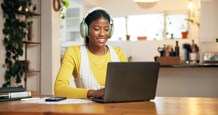 Black woman, student and headphones with laptop, smile and typing for online course at apartment....