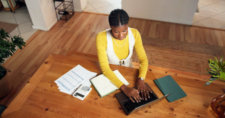 Documents, laptop and black woman in office typing for finance report with email for communication....