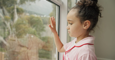 Sad, kid and thinking at window in home with stress, abandoned and trauma from separation....